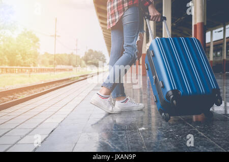 Fille avec un voyageur assurance en attente de train sur la station. Voyager en train de l'aventure de plein air concept avec filtre vintage Banque D'Images