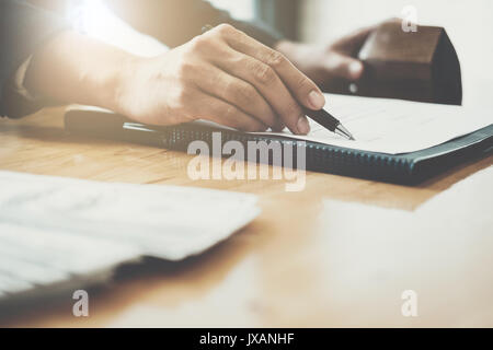 Il suffit de mettre votre signature ici ! Cheerful young man signer certains documents Banque D'Images