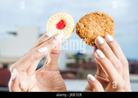 Woman's hands holding deux différentes sortes de biscuits Banque D'Images