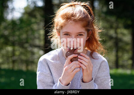 Jeune fille avec lapin de Pâques en chocolat, les morsures en lapin de Pâques, Pâques, Haute-Bavière, Bavière, Allemagne Banque D'Images