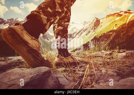 Les randonneurs rendez-vous le long de la crête de la montagne. Leg'dans sneakers marche sur des pierres à la lumière du soleil au coucher du soleil. Le concept de la randonnée dans la nature. Banque D'Images