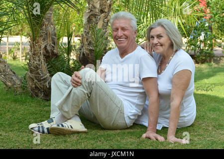 Senior couple sitting on grass Banque D'Images