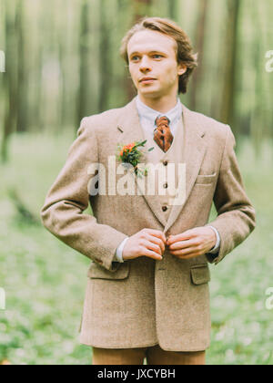 Le portrait du beau blond dans le vintage costume est décoré avec boutonnage veste hir mini-bouquet. Banque D'Images