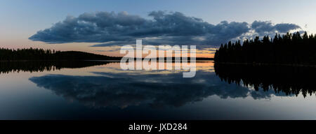 Belle réflexion d'un grand nuage pendant le coucher du soleil à un lac suédois. Banque D'Images