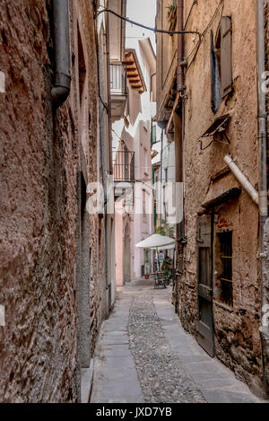 Flexion en étroite ruelle village touristique historique, abattu en journée d'été lumineux à Orta San Giulio, Novara, Cusio, Italie Banque D'Images