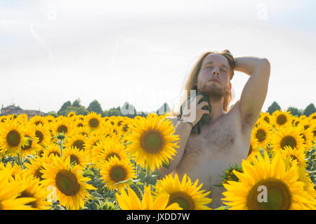 Jeune modèle souffre de chaleur dans un champ de tournesol Banque D'Images