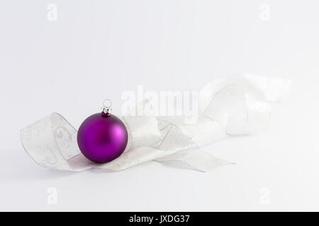 Belle pourpre brillant avec des boules de Noël blanc et argent ruban sur fond blanc Banque D'Images