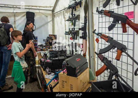 Enfant et les visiteurs qui cherchent à armes à air à vendre, répliques d'armes conçues pour ressembler à de véritables armes à feu de façon réaliste à militaria juste Banque D'Images