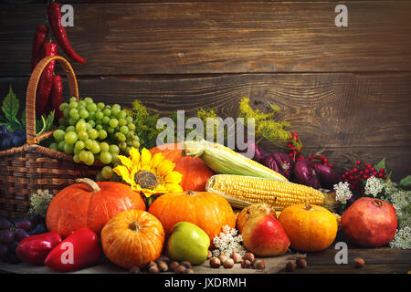 Joyeux Thanksgiving Day background, table en bois décorées de citrouilles, le maïs, les fruits et les feuilles d'automne. Banque D'Images