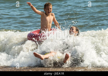 West Bay, Dorset, UK. 15 août, 2017. Météo France : les habitants et les vacanciers profitez d'une chaude après-midi ensoleillée à bronzer et nager à la station balnéaire de West Bay. Crédit Photo : Guy Josse/Alamy Live News Banque D'Images