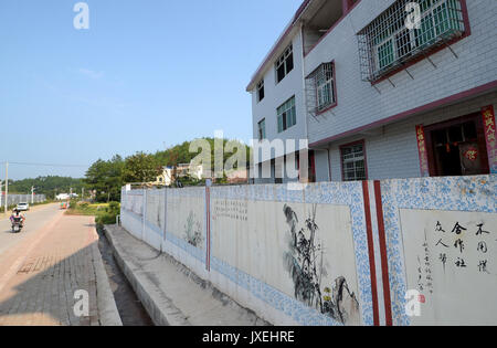 (170816) -- GANZHOU, 16 août 2017 (Xinhua) -- un mur avec des peintures est vu dans Gufang Wenwuba dans village canton de Huichang Comté, Ganzhou City, province de Jiangxi, Chine orientale, le 28 juillet 2017. Depuis 2016, le gouvernement local dans Gufang village prendre des mesures ciblées dans la pauvreté. Les infrastructures, comme les routes, les maisons et l'énergie solaire, lampes, ont été construits et de nouvelles industries ont été introduits dans le village, qui a changé le village de façon spectaculaire. Les étangs à poissons, des serres ainsi que les vergers ont stimulé l'économie agricole locale. Amélioration de l'environnement dans le village a aussi attiré m Banque D'Images