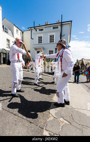 Anglais traditionnel Morris men de Hartley Morris Dancers à l'extérieur de la ville à la rue la semaine annuelle de Broadstairs Folk. La danse de deux lignes portant un pantalon blanc et tee-shirts avec des chapeaux de paille, holding de poteaux. Banque D'Images