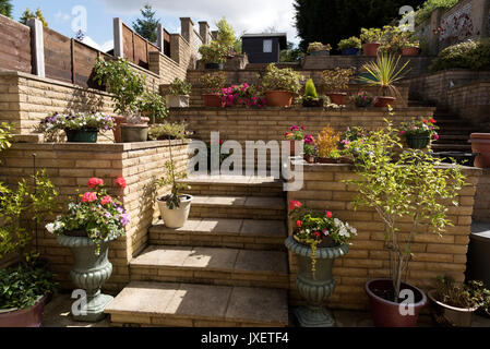 Jardin de banlieue construit avec des murs en brique d'une colline. Solihull Birmingham UK Banque D'Images