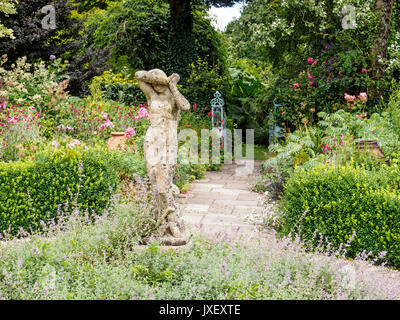 Jeune fille timide stautue le jardin de roses à Burrow Farm Gardens, Devon's Secret Garden à Dalwood près de Axminster est la création de Marie Bérenger. Banque D'Images