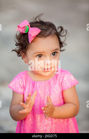 Petite fille vêtue de rose clapping Banque D'Images