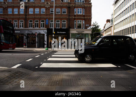 Un passage clouté avec black London Taxi Cab sur passage piétons et bus de Londres qui vient de gauche sur King Street, Sloane Square, Londres. Banque D'Images