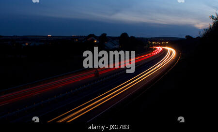 Light trails de voitures en mouvement, sur une double voie rurale Banque D'Images