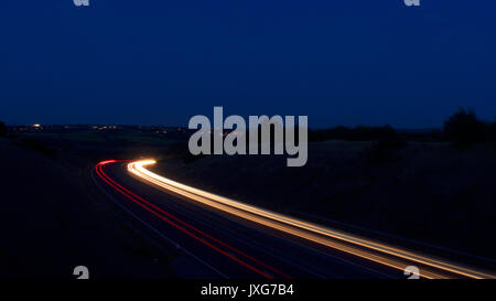 Light trails de voitures en mouvement, sur une double voie rurale Banque D'Images