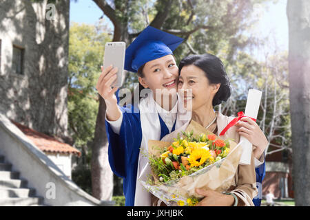 Heureuse mère et fille avec le téléphone retardateur Banque D'Images