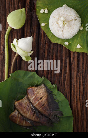 La nourriture thaï et riz frit de poisson séché salé demoiselle avec lotus fleurs de jasmin sur fond de bois décoration Belle télévision lay still life asie rustique Banque D'Images