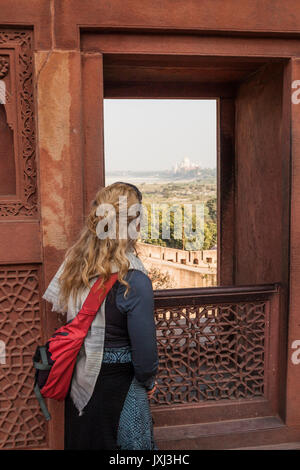 Une femme de Fort d'Agra regarder par la fenêtre vers le Taj Mahal, Agra, Inde. Banque D'Images