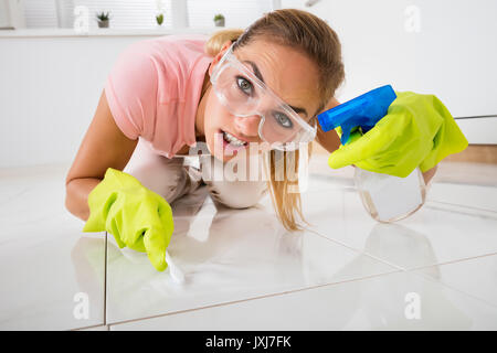 Close-up of a Young Woman Cleaning frustrés avec le pinceau à la maison Banque D'Images