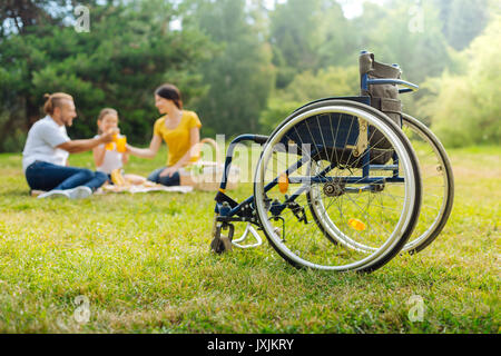 Famille d'un homme handicapé boire du jus on picnic Banque D'Images