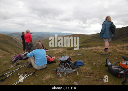 Un groupe de femmes les marcheurs se reposant pour le déjeuner et admirer la vue alors que l'escalade Blencathra dans le Lake District Banque D'Images