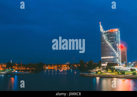 Riga, Lettonie. Urbain pittoresque paysage urbain de centre-ville moderne avec des gratte-ciel et de béton de remblai dans la rivière Daugava sous l'éclairage de nuit Banque D'Images