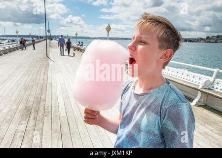 Un touriste de manger de la barbe à papa sur Princess Pier à Torquay, Torbay, Devon, UK Banque D'Images