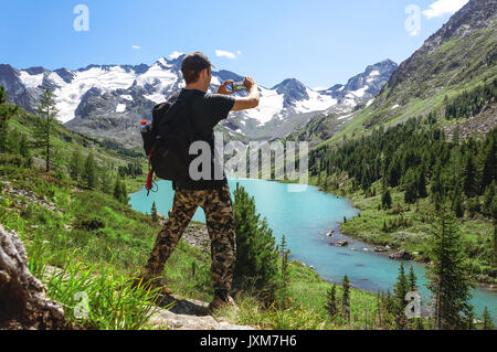 Prend des photos touristiques avec smart phone sur le pic de paysage vallonné. Le magnifique paysage de l'Altaï. Multinskoe lake Banque D'Images