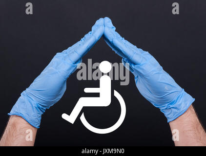 Image conceptuelle de l'aide et des soins pour handicapés isolé sur fond sombre Banque D'Images