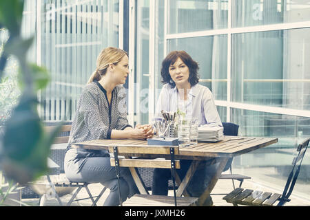 Deux businesswomen having discussion pendant le déjeuner d'affaires à l'extérieur du bureau Banque D'Images