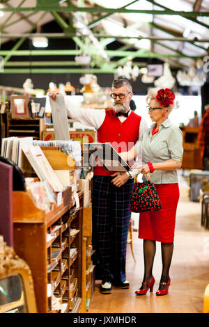 Quirky vintage couple looking at pictures en ancien et vintage emporium Banque D'Images