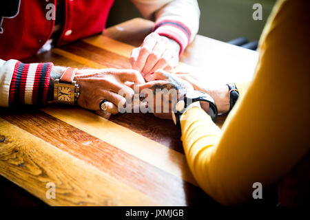 Couple holding hands on table Banque D'Images