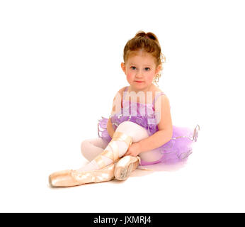 Une petite ballerine tente sur les pointes. Banque D'Images