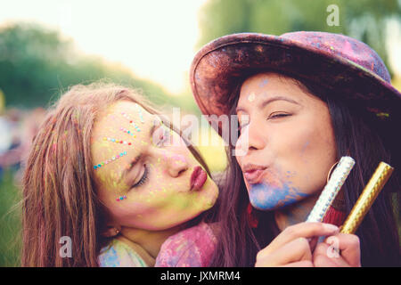 Portrait de deux jeunes femmes vues dans la poudre de craie de couleur puckering lips au festival Banque D'Images