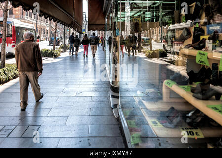 Les gens qui marchent sur la rue Gran Via et reflétée dans la vitrine de l'ancien magasin de chaussures Macias, Granada, Espagne Banque D'Images