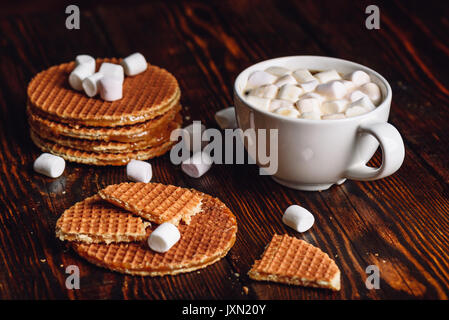 Broken Dutch gaufres avec du blanc tasse de café avec de la guimauve et Waffle Pile. Banque D'Images