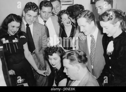Beta Theta Pi, fraternités, Vie étudiante coup franc de fraternité et de leurs petites amies rassemblement autour d'un piano, 1947. Banque D'Images
