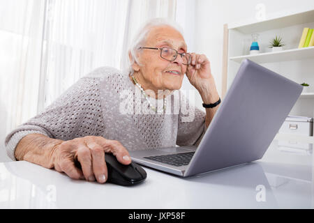 Senior Woman Using Laptop On 24 At Home Banque D'Images