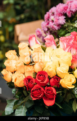 Bouquet de belles roses colorées avec des gouttes d'eau sur le marché. Banque D'Images