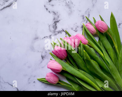 Bouquet de tulipes roses sur une table en marbre. Mise à plat. Le format paysage. Banque D'Images