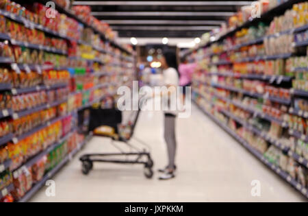Hors focus shot d'une femme avec son panier au supermarché, à la tablette à l'épicerie Banque D'Images