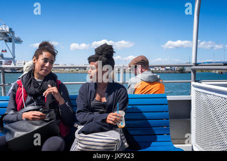 OAKLAND, CALIFORNIE- 13 mai 2017 : deux passagers du traversier Afro-américaines amis parler en route de San Francisco à Oakland. Ciel bleu ensoleillé Banque D'Images