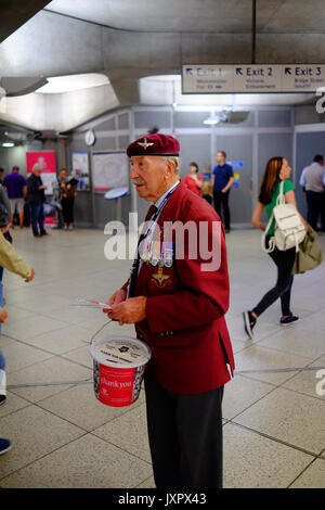 Les anciens combattants de la guerre militaire et navale la collecte à Westminster tube station de taxi pour leur charité. Chacun avait un signet avec leur service photo. Banque D'Images