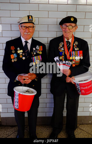 Les anciens combattants de la guerre militaire et navale la collecte à Westminster tube station de taxi pour leur charité. Chacun avait un signet avec leur service photo. Banque D'Images