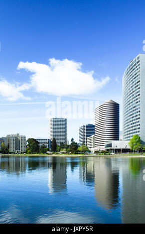 Oakland, Californie downtown Lake Merritt sur une journée ensoleillée. Les toits de bâtiments et reflétée dans l'eau. La verticale Banque D'Images