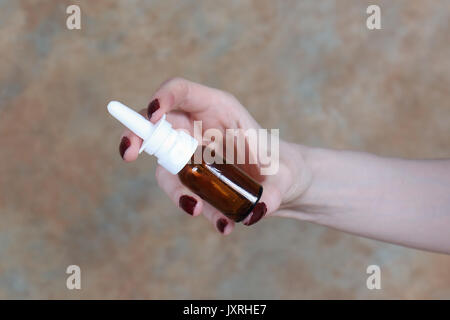 Woman holding nasal spray pompe dans des contenants de verre dans sa main Banque D'Images