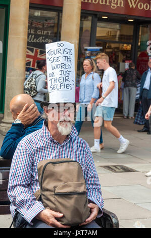 Bath, Somerset, Royaume-Uni. 17 août 2017. Un homme, un silence et une manifestation pacifique contre les touristes et le tourisme en général avec un signe sur son chapeau la lecture, 'Do touristes 'voir le monde' ou juste leurs autoportraits ?' . Crédit : Richard Wayman/Alamy Live News Banque D'Images